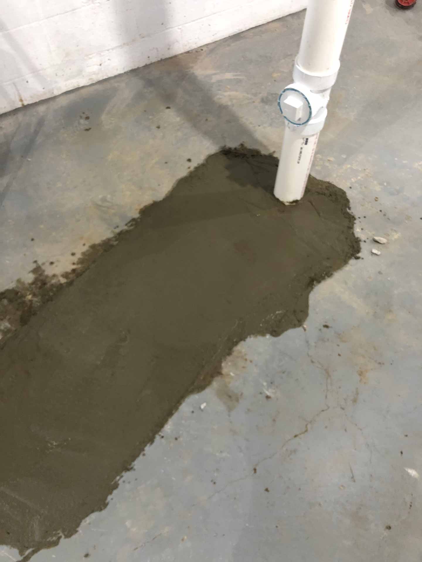Hole in basement floor patched up with fresh concrete