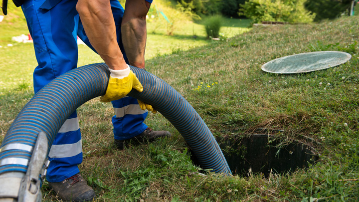 Worker cleaning out sewer drain