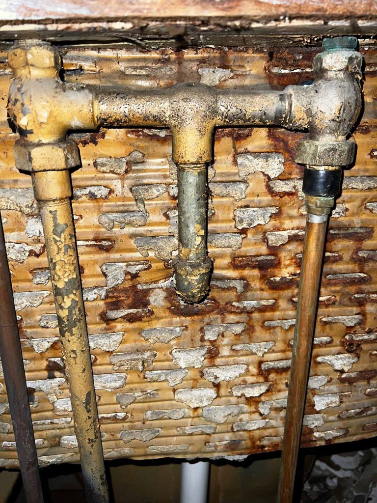 Copper pipes with peeling paint in basement